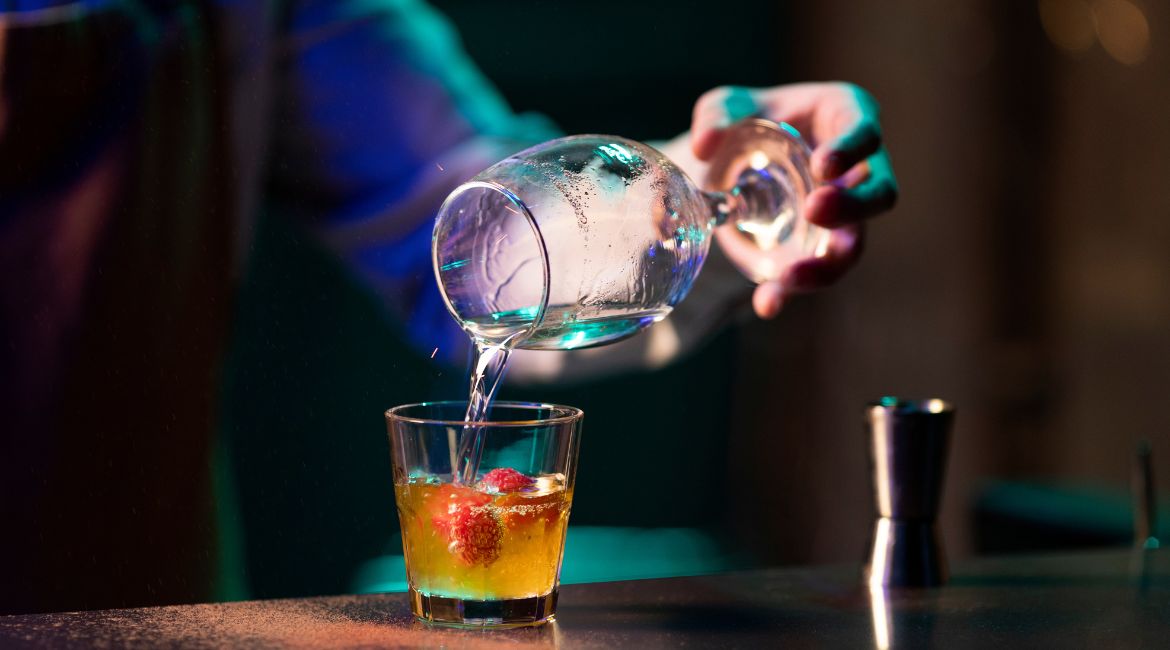 In un cocktail bar a Roma centro, un bartender prepara un drink