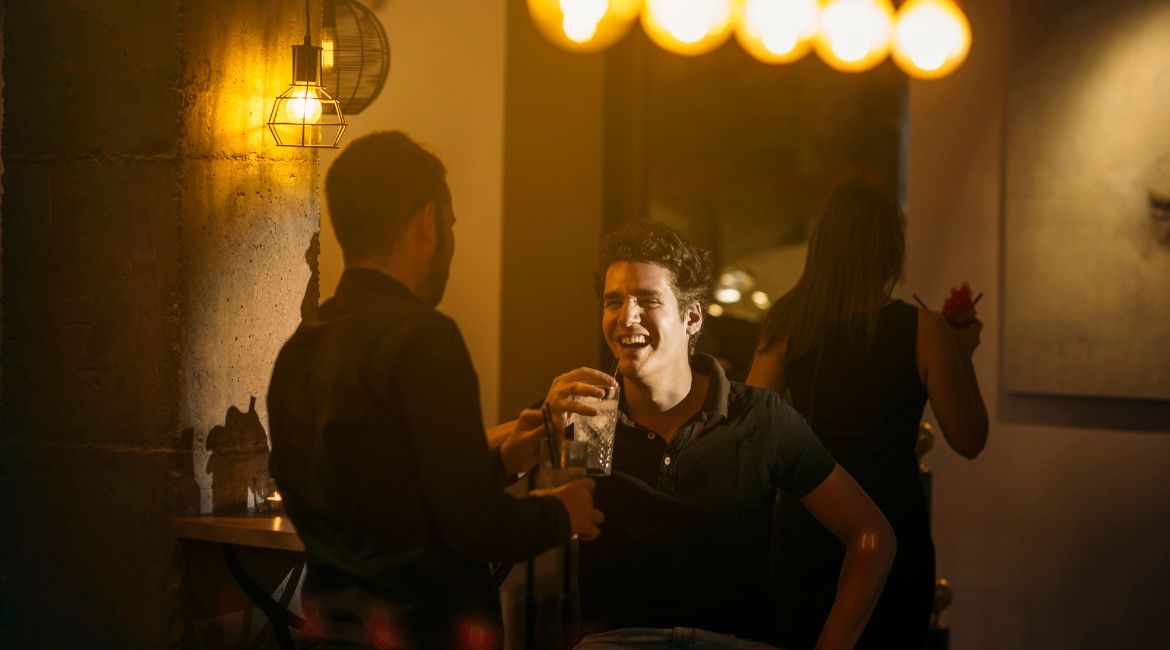 Due amici chiacchierano e si godono un drink in uno dei migliori speakeasy in Italia